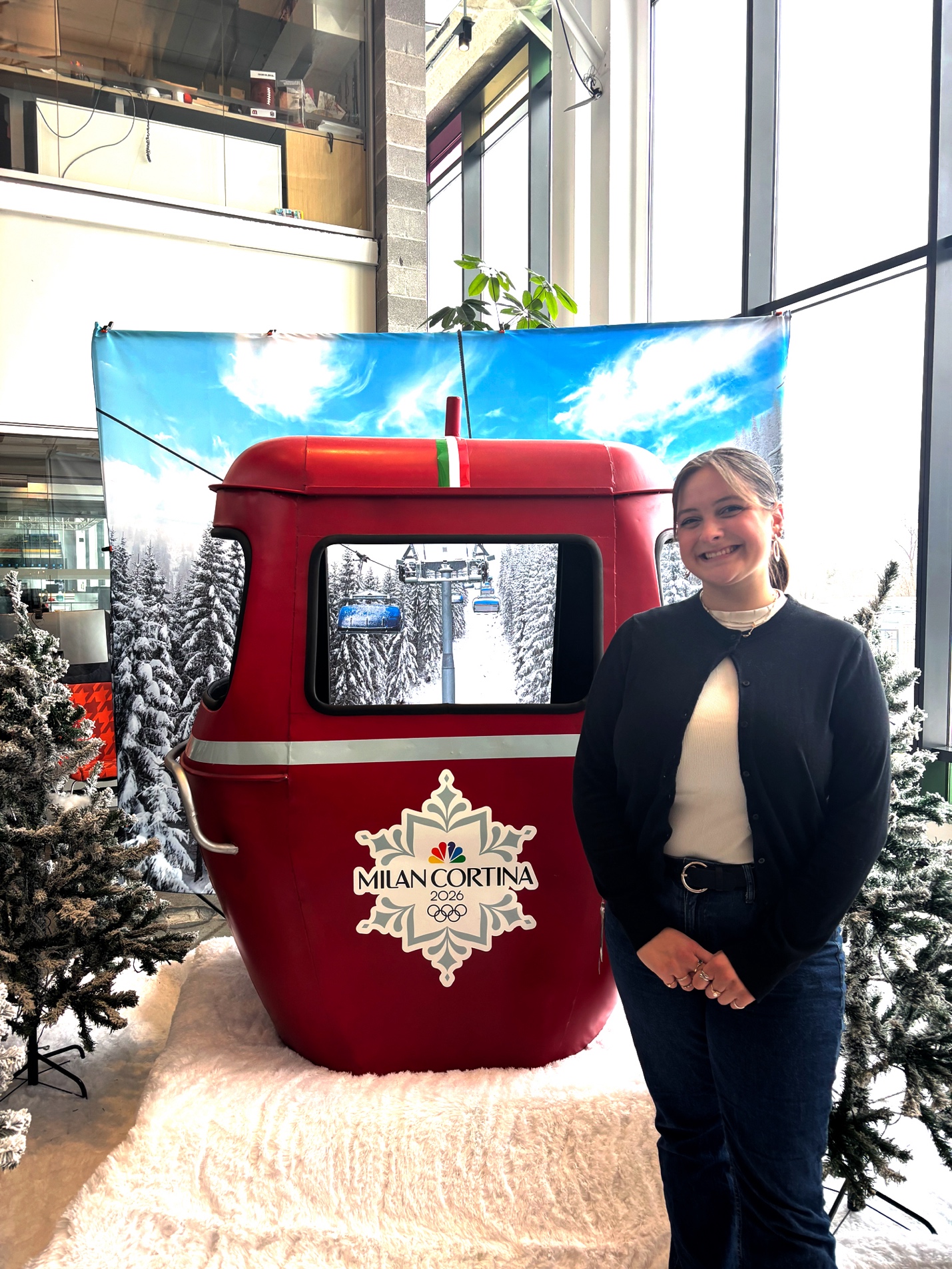 Emily Abert poses by the Milan Cortina gondola installation at NBC Sports Headquarters in Stamford, CT