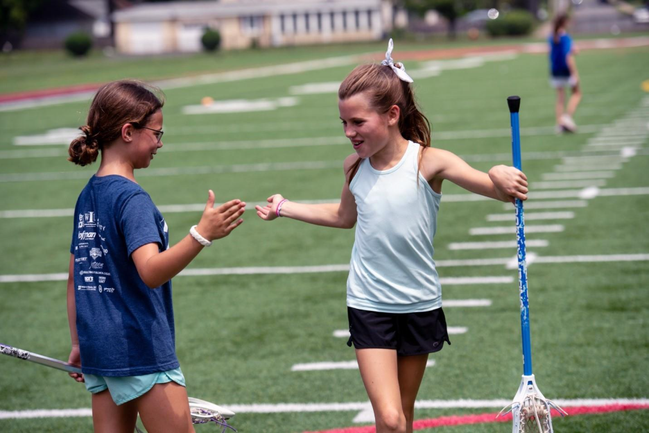 A child holding a racket and giving a high fiveAI-generated content may be incorrect.